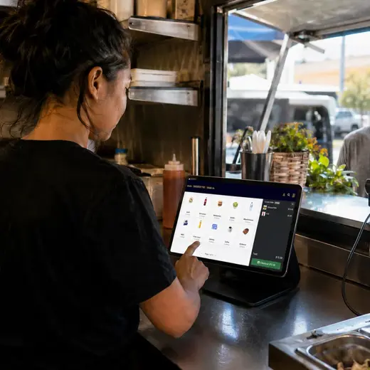 Food truck operator entering a customer order on a protected tablet